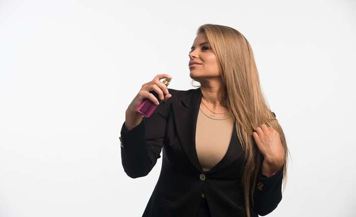 young businesswoman black suit applies perfume her neck 114579 15842